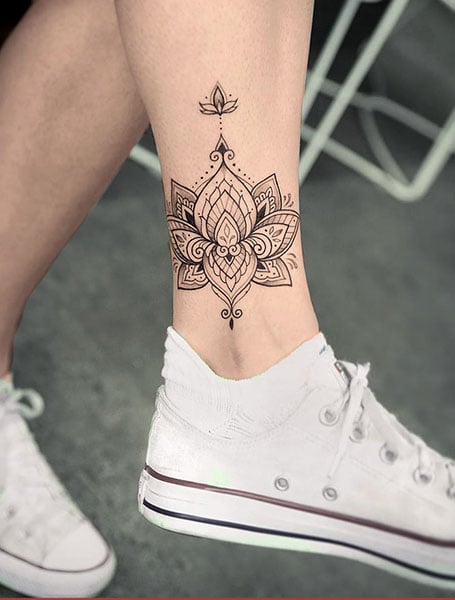 Fine line lotus flower tattoo on the thigh