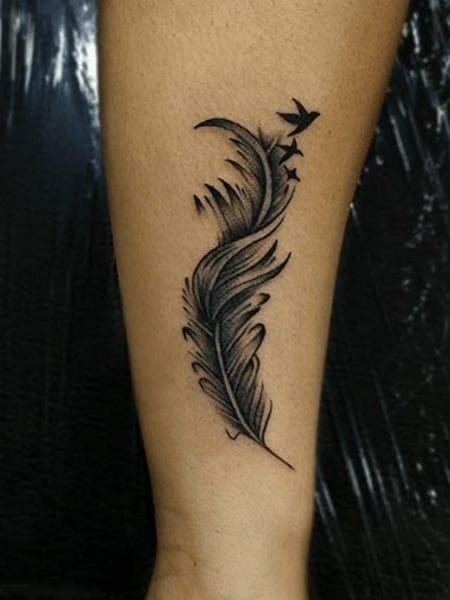 Palm leaf and bird tattoo on the left thigh