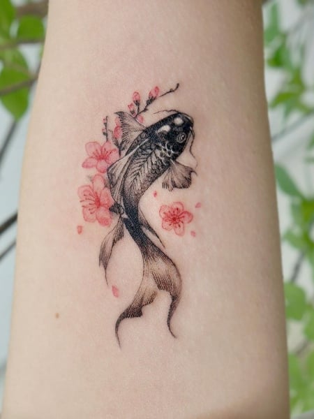 Koi fish and lily flower tattoo located on the tricep