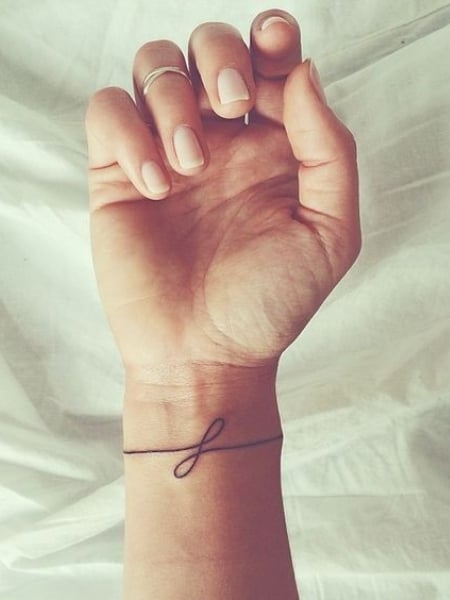Little Tattoos — Wrist tattoo of a minimalist lotus flower on...