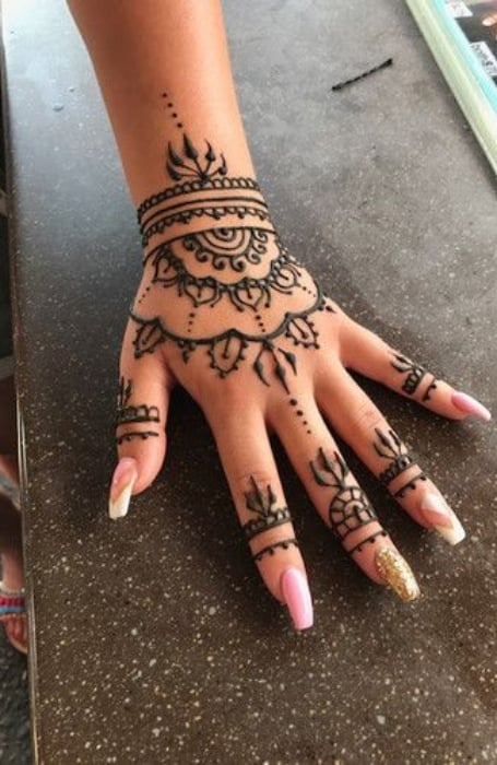 An artist hand freestyle drawing a henna tattoo design up a ladies leg  Stock Photo - Alamy