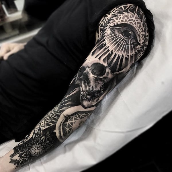 Black shaded geometric skull tattoo on full sleeve by Orgestc