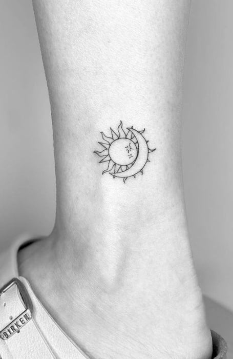 Minimalist crescent moon tattoo on the hand.